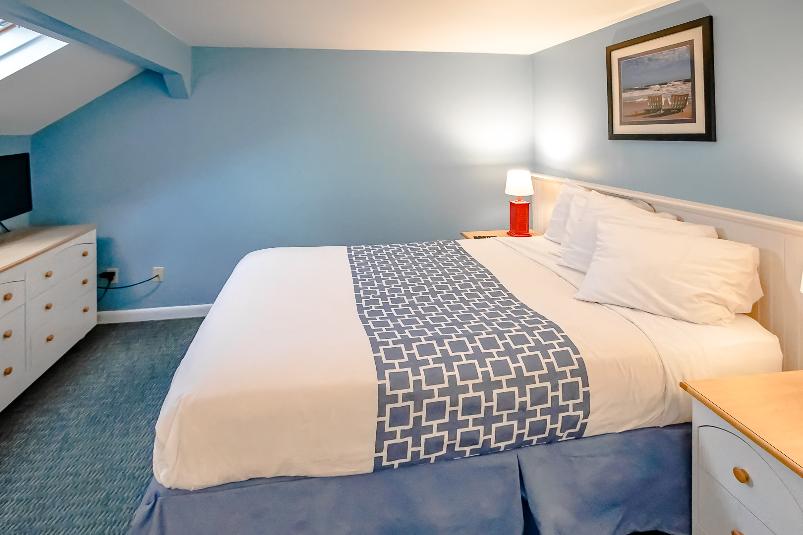 A master bedroom with a king size bed at VRI's Seawinds II Resort in Massachusetts.